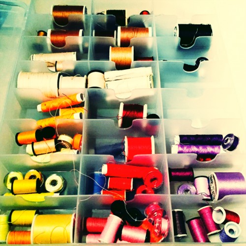image of spools of thread in red orange yellow and purple hues
