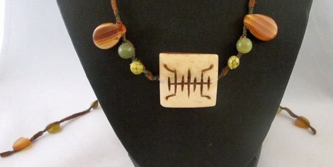 photo of necklace made by Homegrown Crafts with suede earth tone beads and carved bone centerpiece