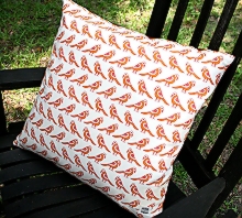 photo of pillow slip cover made by Homegrown Crafts out of a repurposed dinner napkin with orange and red bird print and red backing material