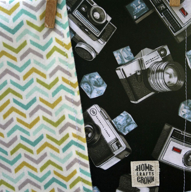 photo of reversible toddler blanket maed by Homegrown Crafts featuring multi colored chevron flannel and a cotton retro camera print