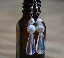 Clearly elegant earrings displayed on bottle