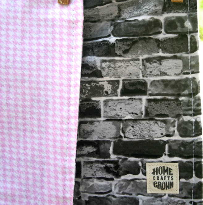 reversible toddler blanket made by Homegrown Crafts featuring flannel with pink and white houndstooth and cotton brick wall print