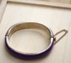 top view of purple acrylic abd gold tone bangle showing safty chain