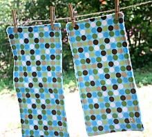 Photo of two burp cloths made by Homegrown Crafts with polka dot multi colored flannel with blues, browns, greens, and white