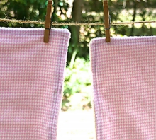 photo of two burp cloths made by Homegrown Crafts featuring flannel with pink and white houndstooth pattern