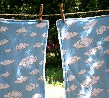 photo of two burp cloths made by Homegrown Crafts featuring flannel with blue and white cloud print