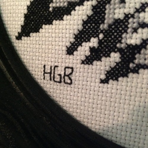 Close up of initials HGB cross stitched with black thread
